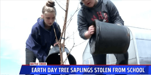 Two students planting trees, heading underneath reads, Earth Day Tree Saplings Stolen
