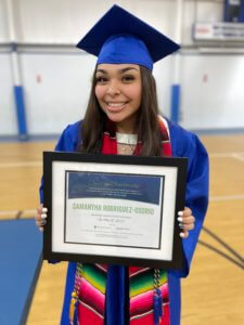 Samantha Rodriguez-Osorio holding certificate at graduation