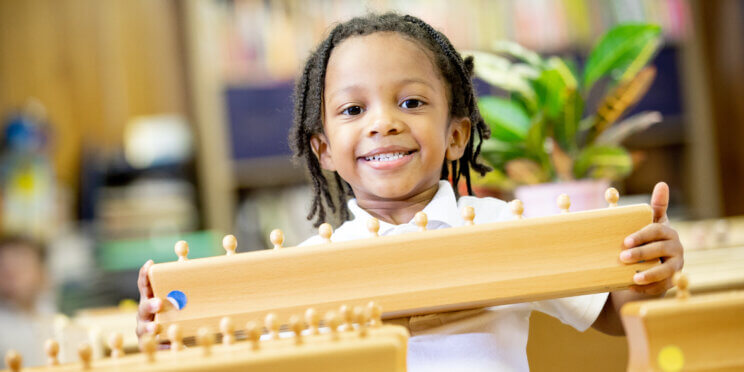 Young student holding Montessori materials