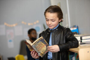 Photo of a child at schools managed by Choice Schools Associates reading a book in the classroom.